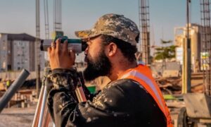 Construction staking commercial building - ALTA SURVEY North Dakota A surveyor carrying out construction staking with a theodolite at a commercial building site