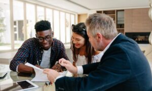 Alta survey purchase closing real estate review - ALTA SURVEY North Dakota Buyers reviewing property purchase documents with a real estate professional before closing